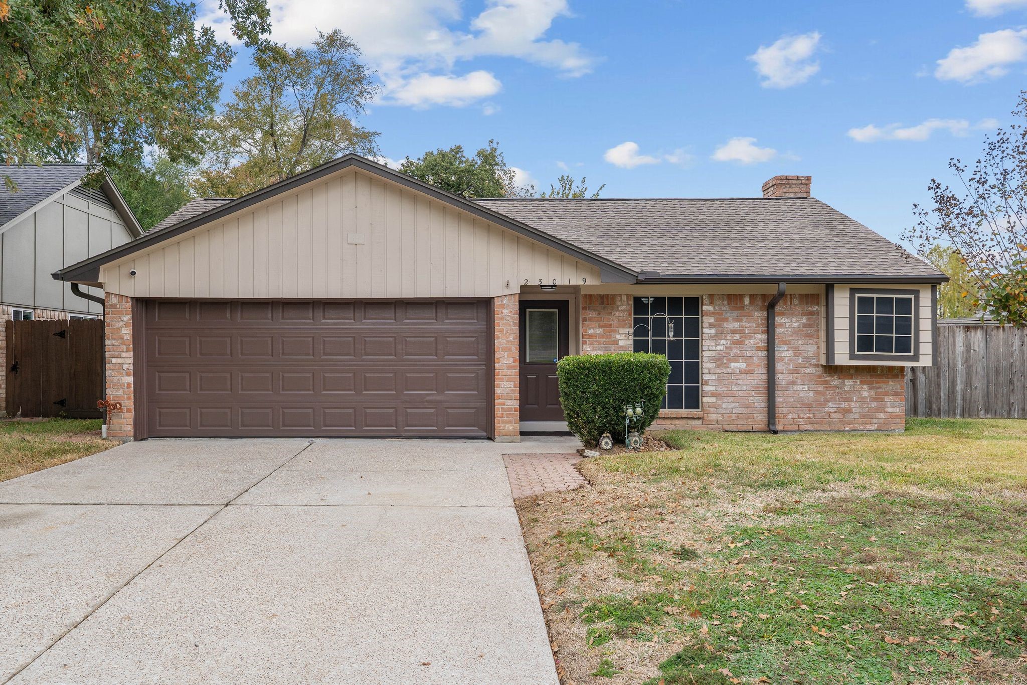 a front view of house with yard and trees in the background
