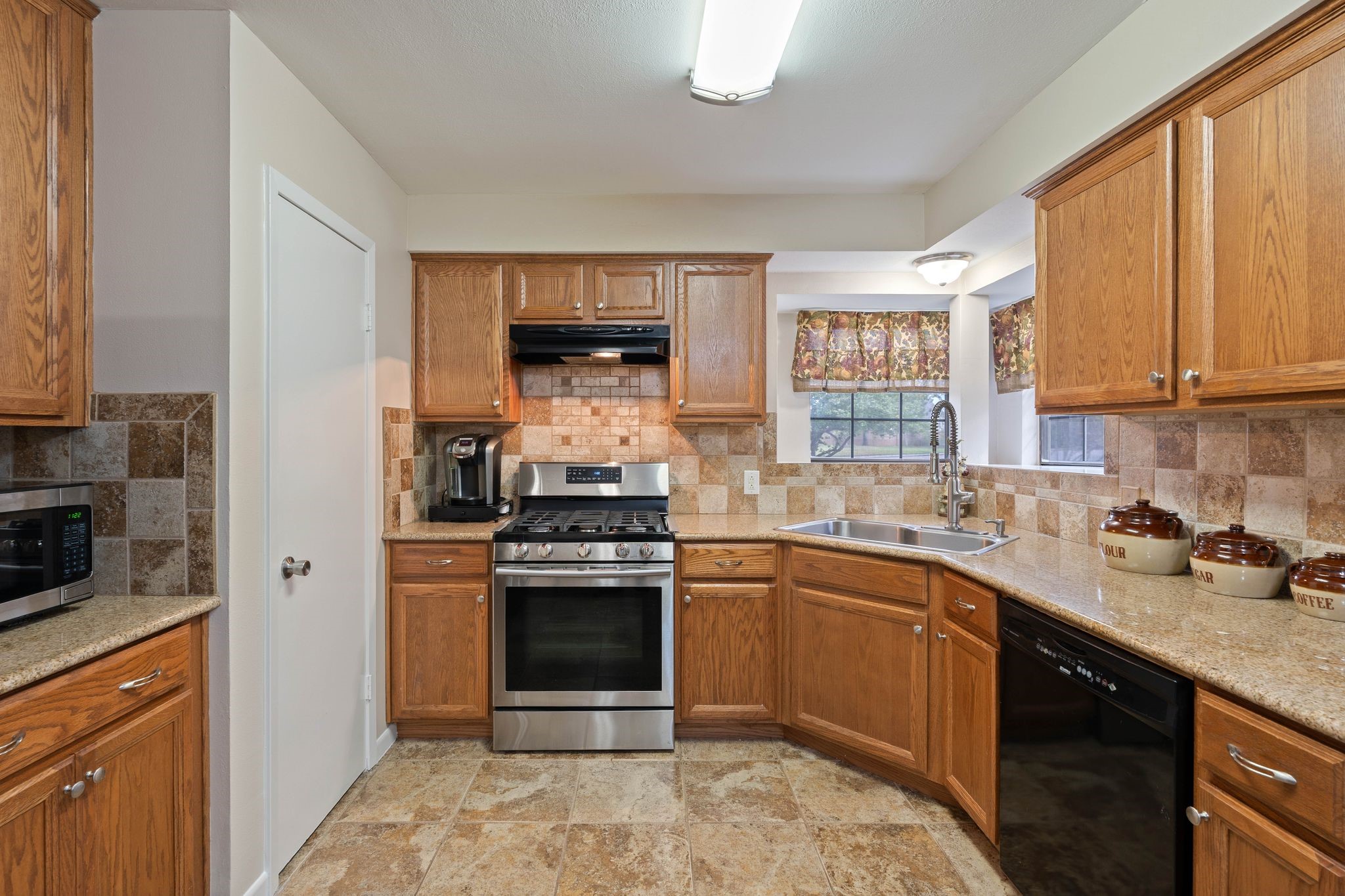 23019 Rothwood Road Spring, TX 77389 - Photo 11 of 30 a kitchen with stainless steel appliances granite countertop a stove sink and cabinets