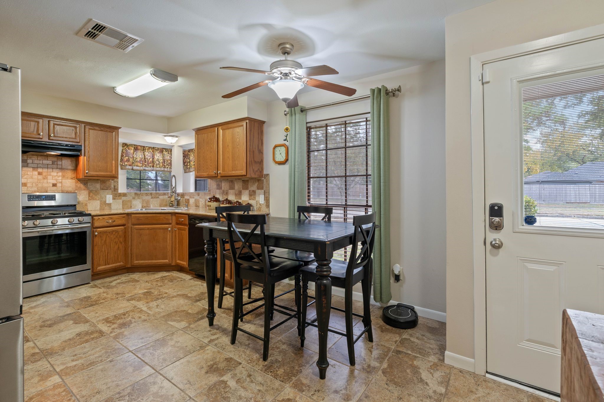 23019 Rothwood Road Spring, TX 77389 - Photo 15 of 30 a kitchen with a table chairs refrigerator and cabinets