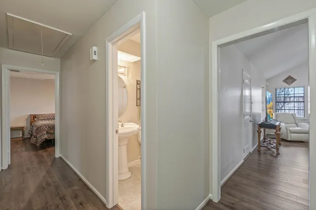 a view of a hallway and wooden floor and livingroom with furniture