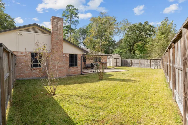 a view of a swimming pool with a patio and a yard