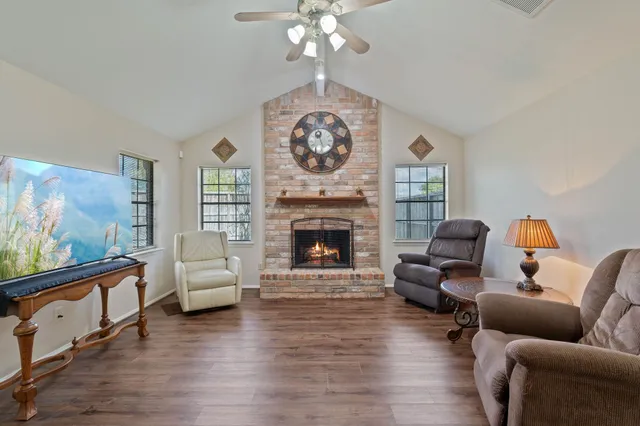 a living room with furniture a large window and a fireplace