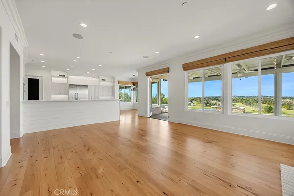 an empty room with wooden floor fireplace and windows