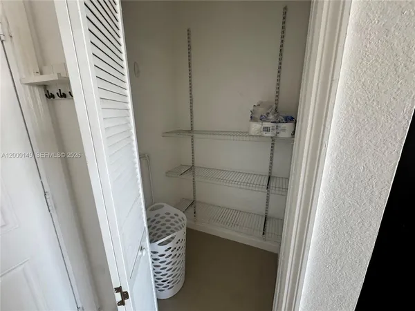 a bedroom with a bed and a refrigerator