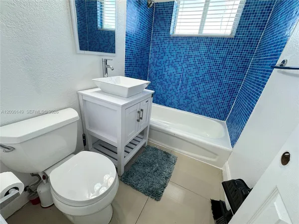a white toilet sitting next to a bath tub
