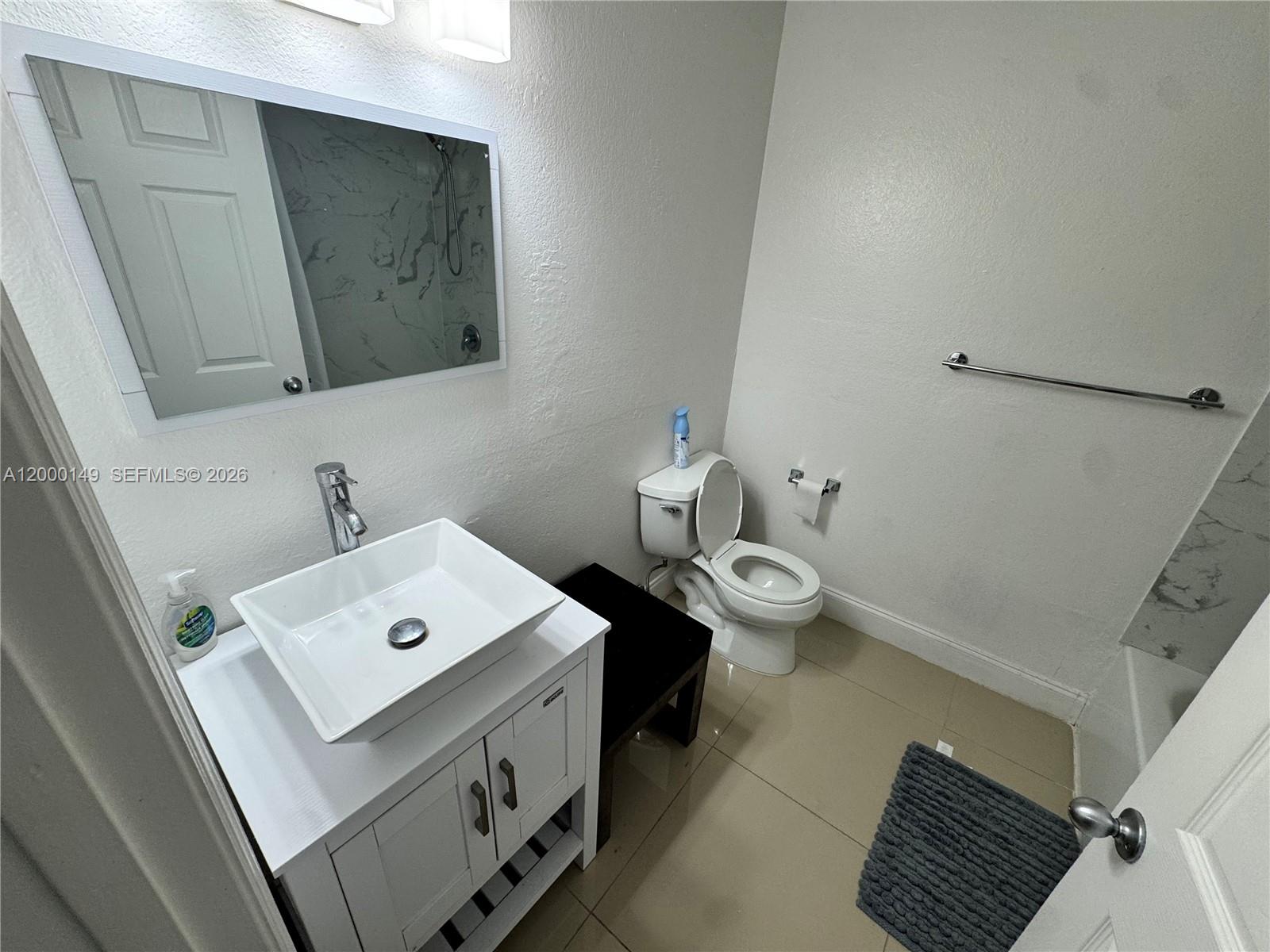 8415 Harding Avenue, Unit 9 Miami Beach, FL 33141 - Photo 8 of 14 a bathroom with a toilet sink and mirror