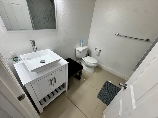a bathroom with a sink toilet and mirror