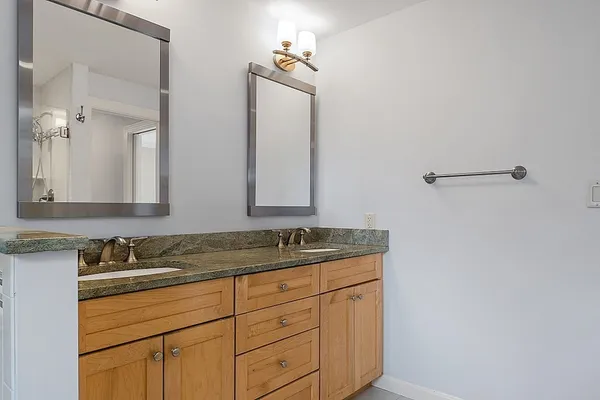 a bathroom with a granite countertop sink and a mirror