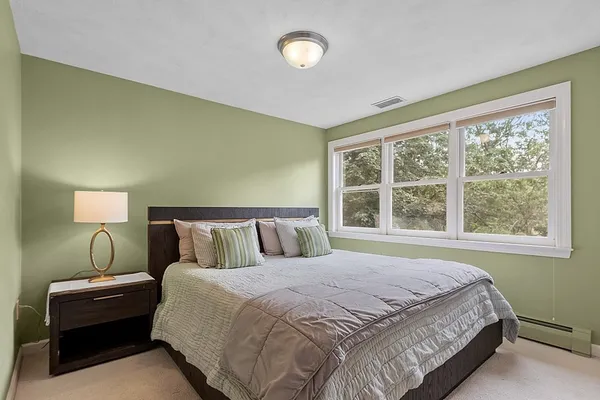 a bedroom with a bed and a large window