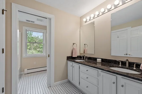 a view of a double vanity sink and a window