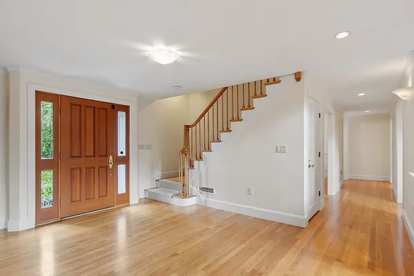 a view of empty room with wooden floor and entryway