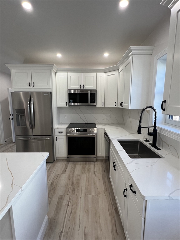 a kitchen with kitchen island a sink stainless steel appliances and cabinets
