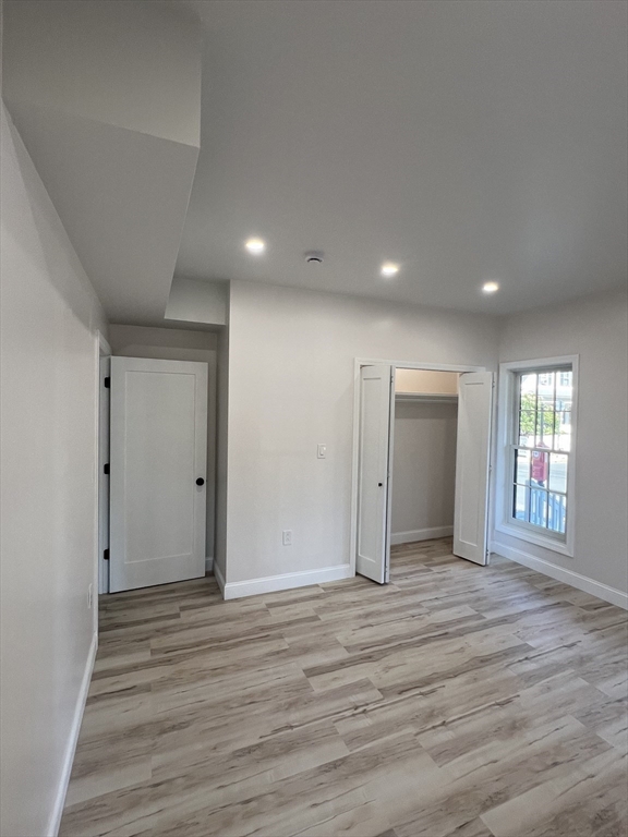 31 Old Morton Street, Unit 1 Boston, MA 02126 - Photo 11 of 17 a view of an empty room with wooden floor and a window
