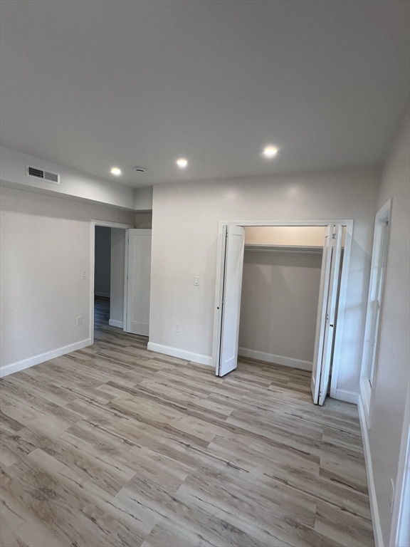 31 Old Morton Street, Unit 1 Boston, MA 02126 - Photo 13 of 17 a view of an empty room with wooden floor and closet