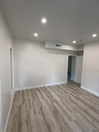 a view of empty room with wooden floor