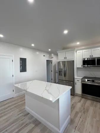 a large kitchen with stainless steel appliances kitchen island a sink dishwasher a refrigerator and a stove