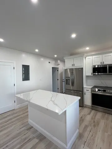 a large kitchen with stainless steel appliances kitchen island a sink dishwasher a refrigerator and a stove