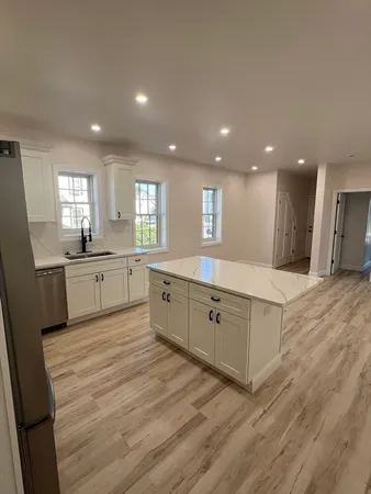 a large kitchen with a lot of counter space and wooden floor