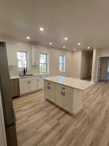 a large kitchen with a lot of counter space and wooden floor
