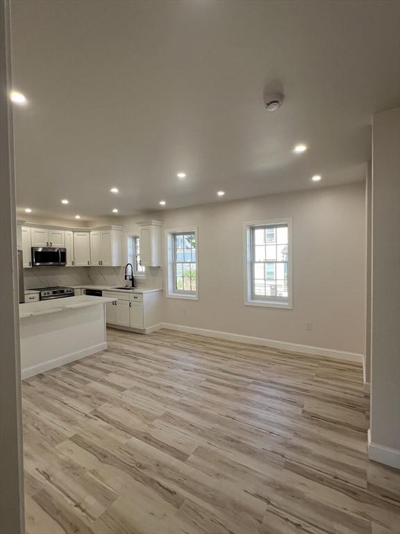 31 Old Morton Street, Unit 1 Boston, MA 02126 - Photo 4 of 17 a view of an empty room with kitchen and window