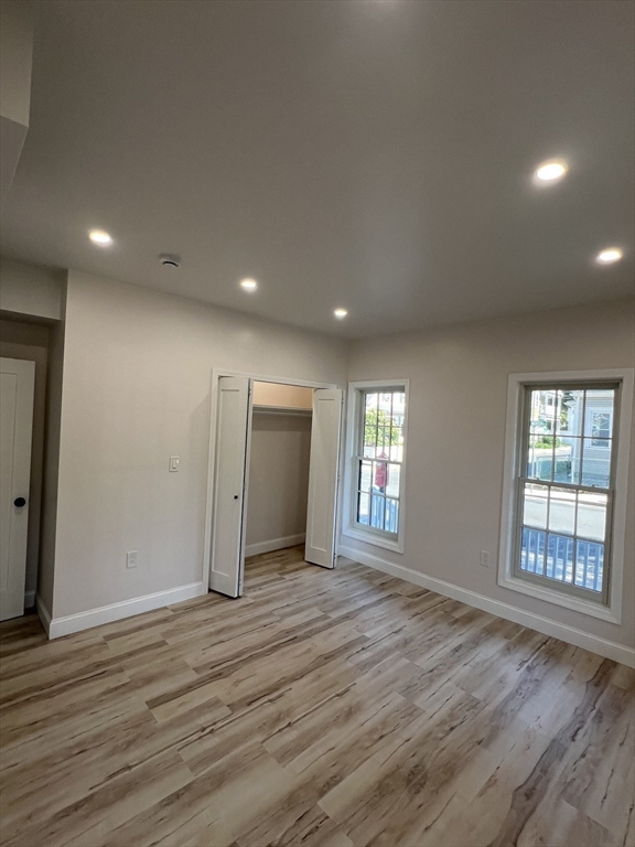31 Old Morton Street, Unit 1 Boston, MA 02126 - Photo 9 of 17 an empty room with wooden floor and windows