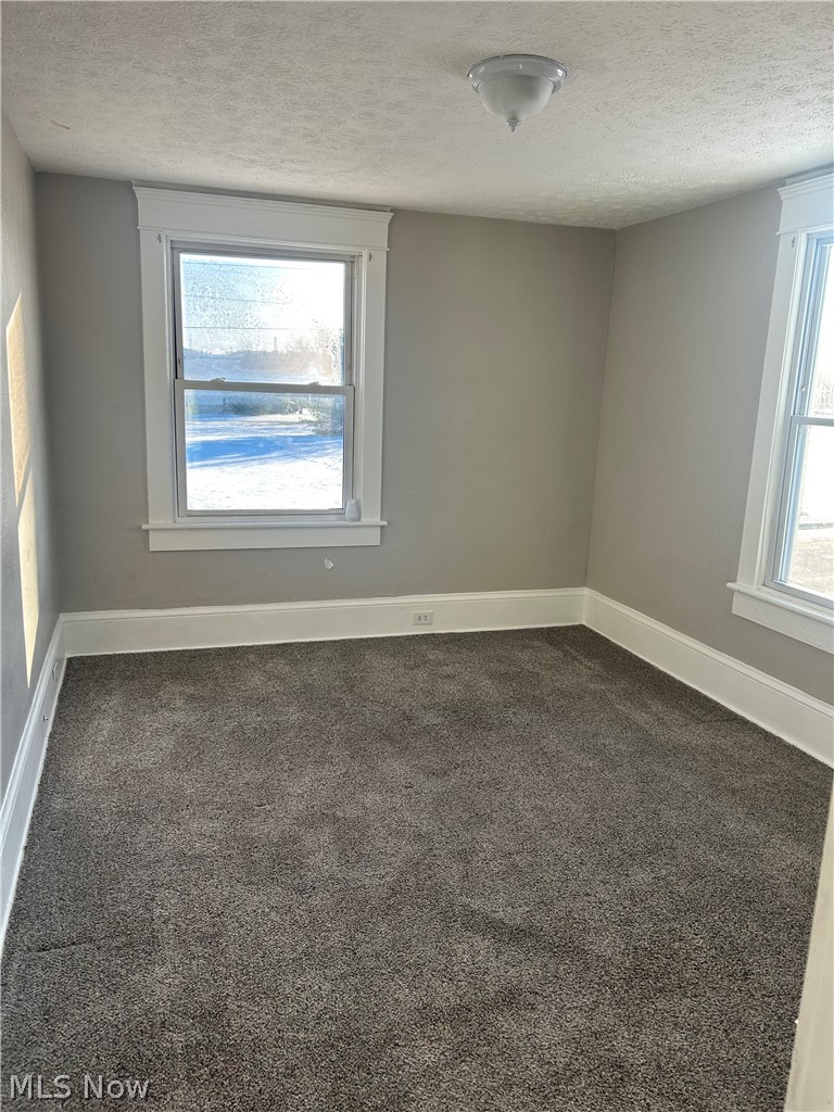 679 Wooster Road West Barberton, OH 44203 - Photo 16 of 16 Carpeted interior space featuring neutral wall tones, white trim, and a ceiling-mounted light fixture