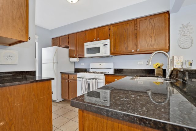 43 North Oltendorf Road Streamwood, IL 60107 - Photo 5 of 22 a kitchen with granite countertop a refrigerator stove top oven and sink