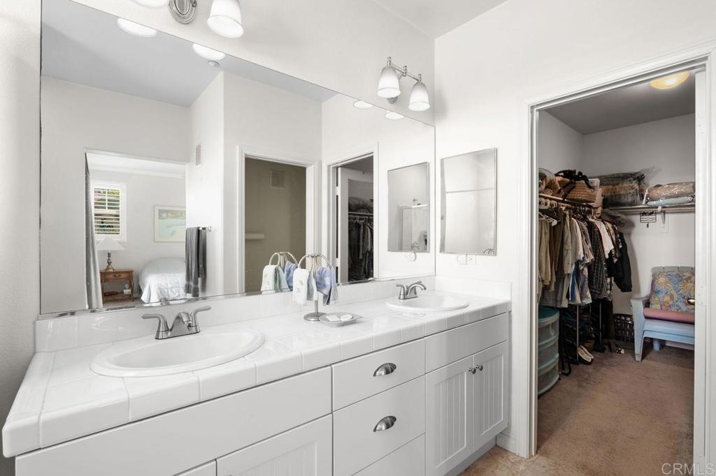 810 Harbor Cliff Way, Unit 225 Oceanside, CA 92054 - Photo 16 of 43 a bathroom with a double vanity sink and a mirror