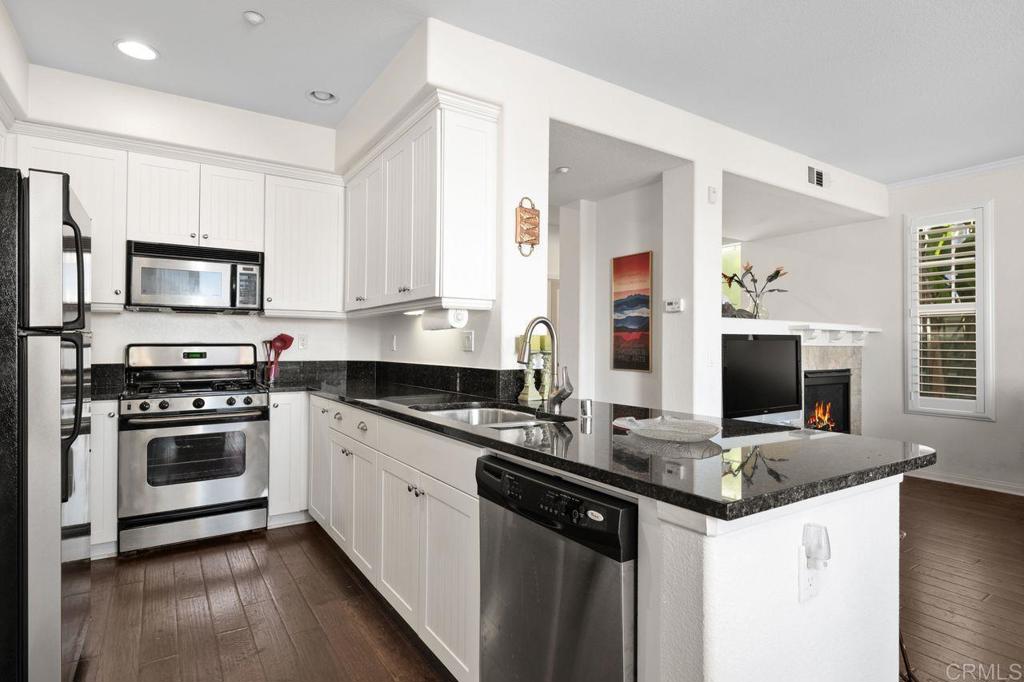 810 Harbor Cliff Way, Unit 225 Oceanside, CA 92054 - Photo 35 of 43 a kitchen with stainless steel appliances a stove microwave and sink