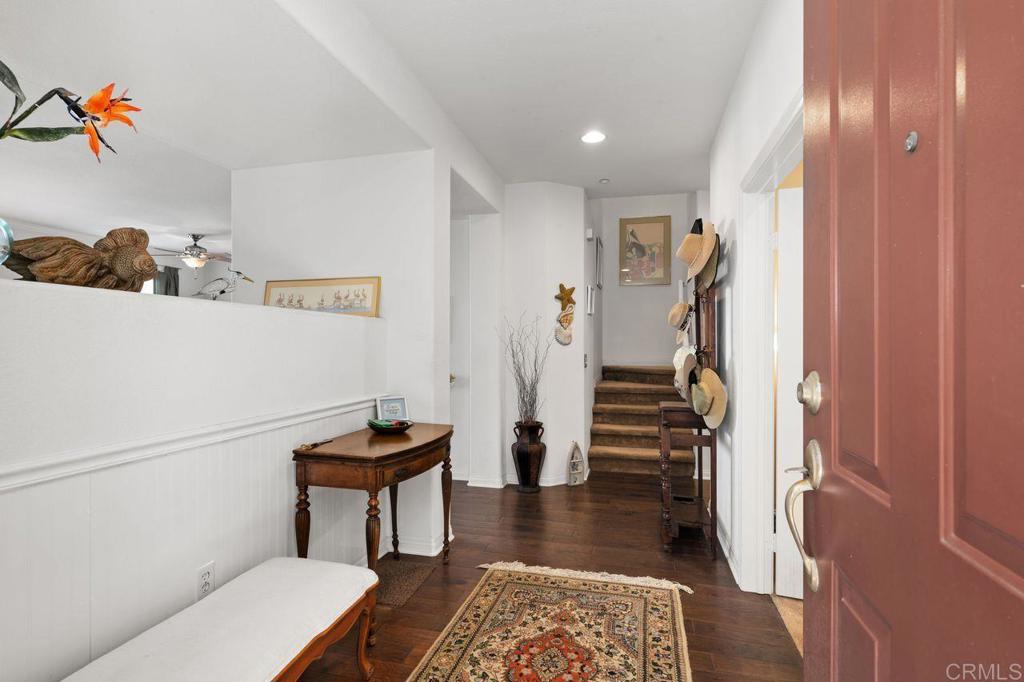 810 Harbor Cliff Way, Unit 225 Oceanside, CA 92054 - Photo 40 of 43 a hallway with a couch and a dining table with wooden floor