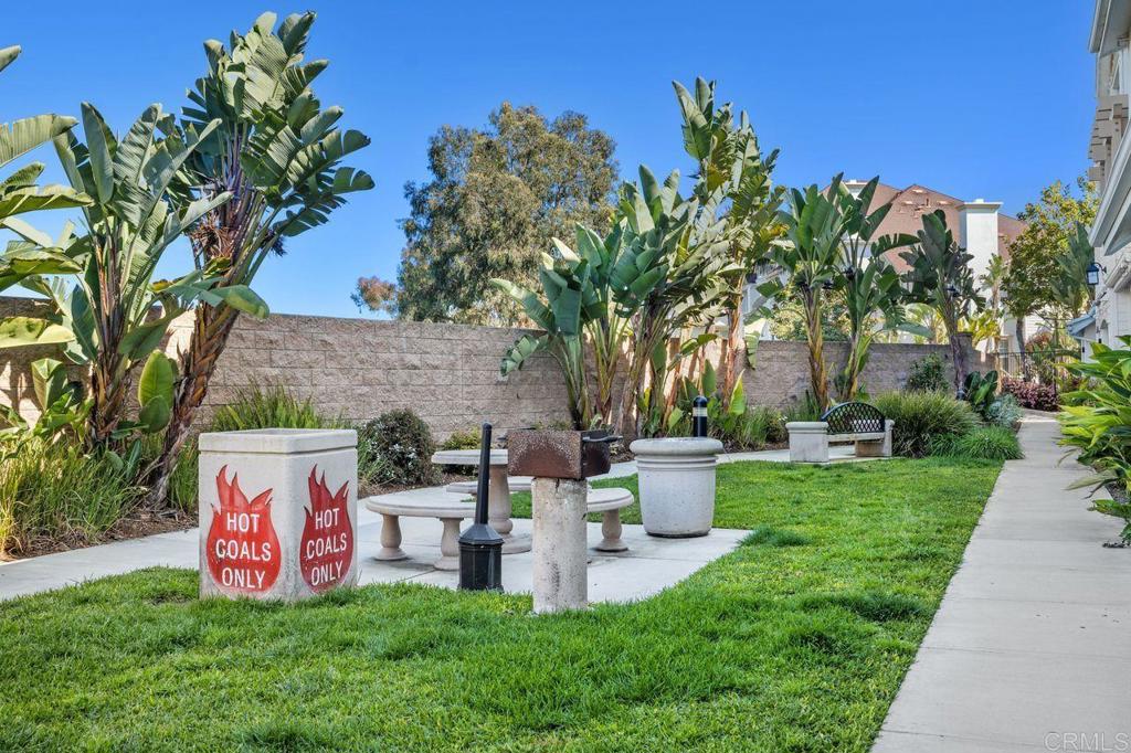 810 Harbor Cliff Way, Unit 225 Oceanside, CA 92054 - Photo 42 of 43 a view of a patio with table and chairs potted plants and large tree