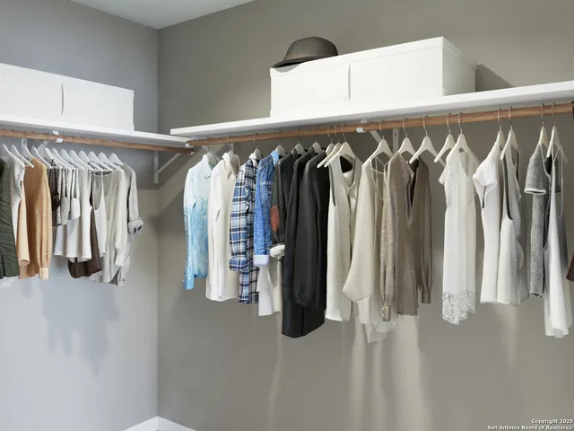 a view of walk in closet with clothes and shoes