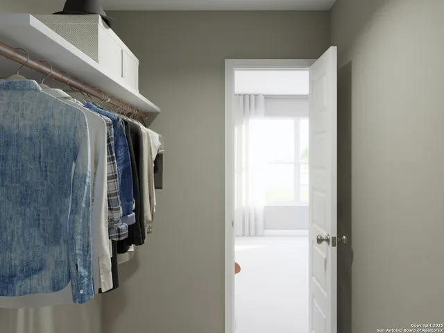 a view of walk in closet with clothes