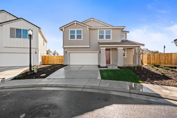 a front view of a house with garage and parking