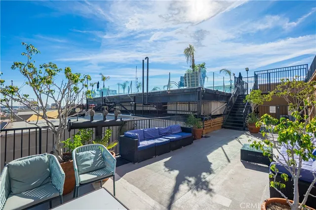 a view of a patio with couches table and chairs potted plants