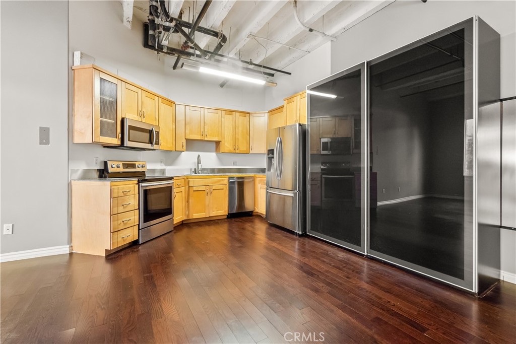 312 West 5th Street Los Angeles, CA 90013 - Photo 5 of 19 a kitchen with stainless steel appliances granite countertop a refrigerator a stove a sink and a microwave