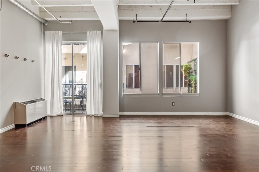 312 West 5th Street Los Angeles, CA 90013 - Photo 8 of 19 a view of an empty room with wooden floor and a window