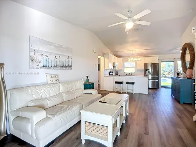 a living room with furniture and kitchen view