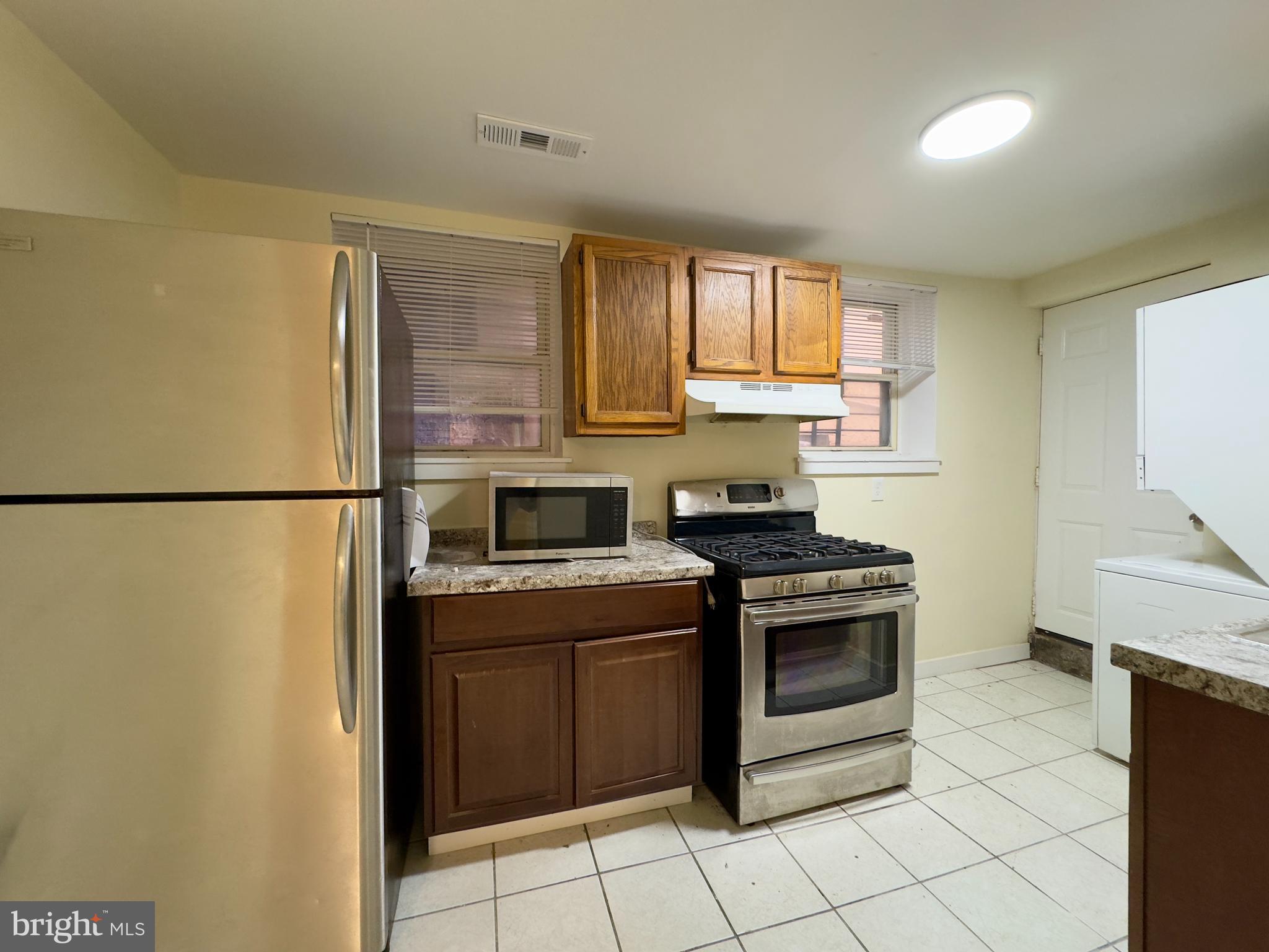 2102 Maryland Avenue Baltimore, MD 21218 - Photo 12 of 14 a kitchen with a stove top oven sink and cabinets