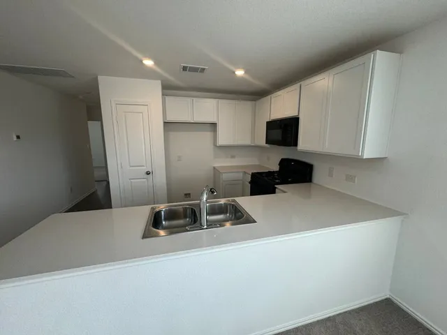 a kitchen with a stove and a wooden floor