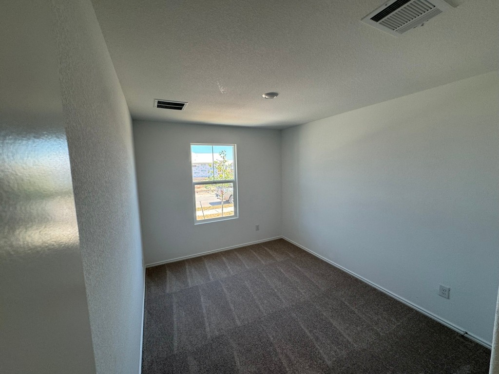 134 Avre Loop Kyle, TX 78640 - Photo 6 of 9 Spare room or 4th bedroom featuring dark colored carpet and a textured ceiling