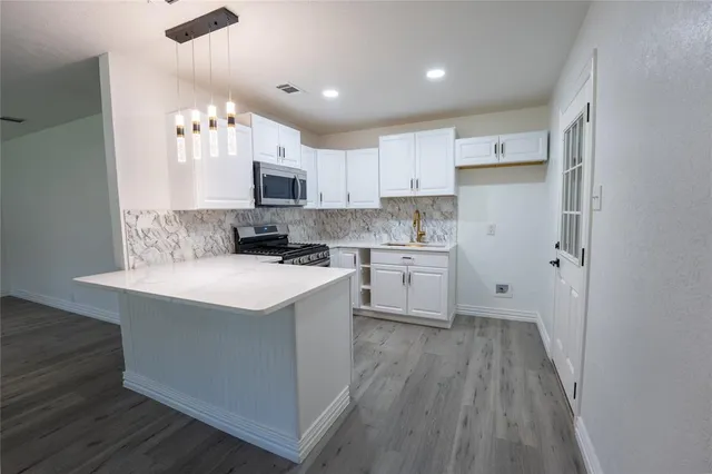 a kitchen with a sink cabinets and wooden floor