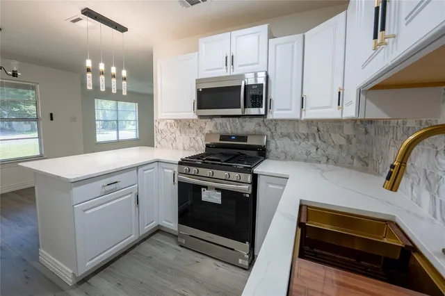 a kitchen with white cabinets and appliances