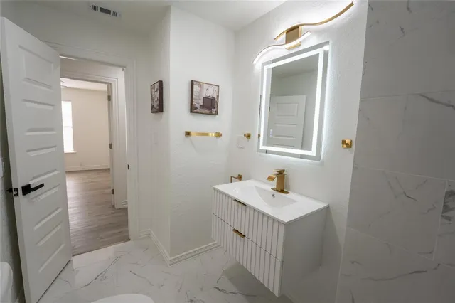 a bathroom with a sink and mirror with toilet