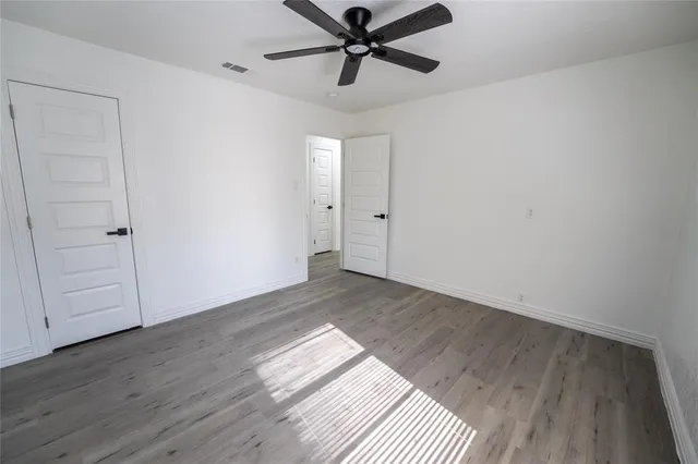 a view of a room with wooden floor and a ceiling fan