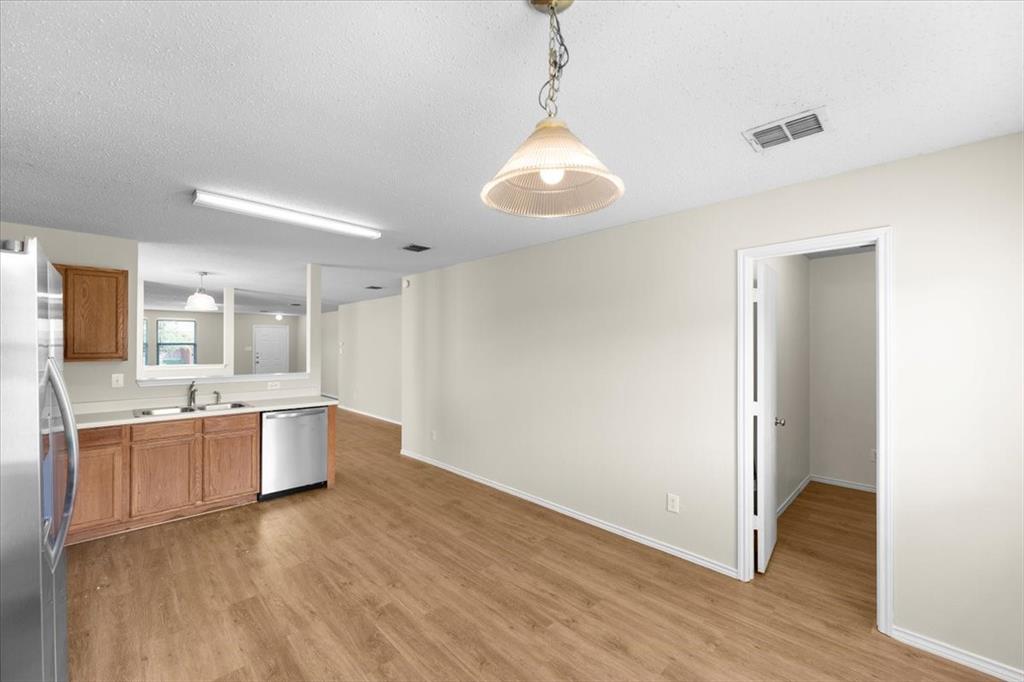 2633 Salt Maker Way Little Elm, TX 75068 - Photo 12 of 40 a large kitchen with a wooden floor and a refrigerator