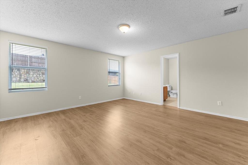 2633 Salt Maker Way Little Elm, TX 75068 - Photo 14 of 40 a view of an empty room with wooden floor and a window