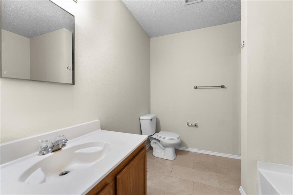 2633 Salt Maker Way Little Elm, TX 75068 - Photo 17 of 40 a bathroom with a sink a toilet and a mirror