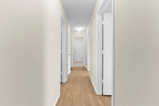 a view of a hallway with wooden floor