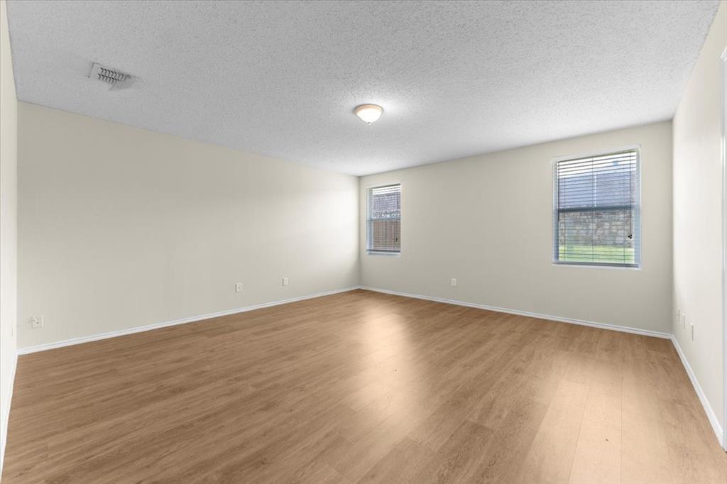 2633 Salt Maker Way Little Elm, TX 75068 - Photo 30 of 40 an empty room with wooden floor and windows